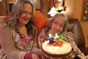 Two ladies holding a cake